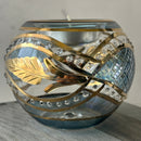 Decorative object with gold and silver design on a textured surface