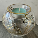 Decorative glass candle holder with gold accents on a marble surface