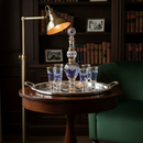 Vintage-style room with a wooden table, brass lamp, and decorative glasses.