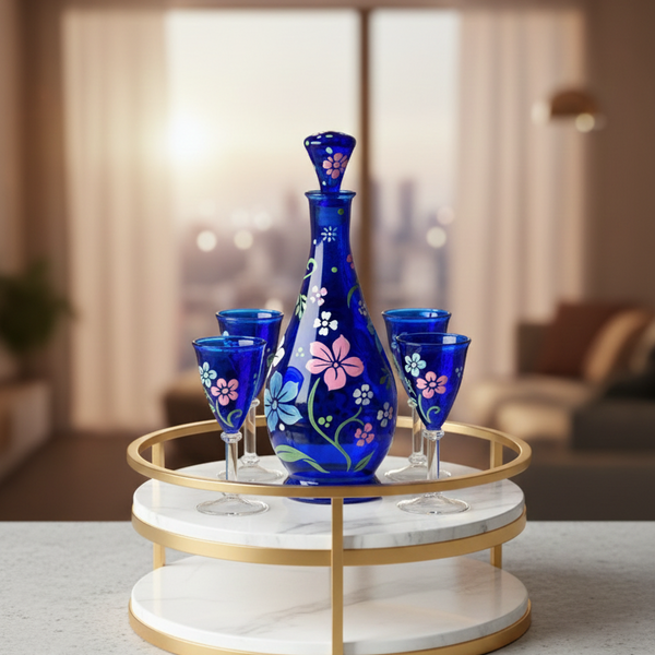 Set of blue glassware with floral designs on a marble tray in a modern living room.