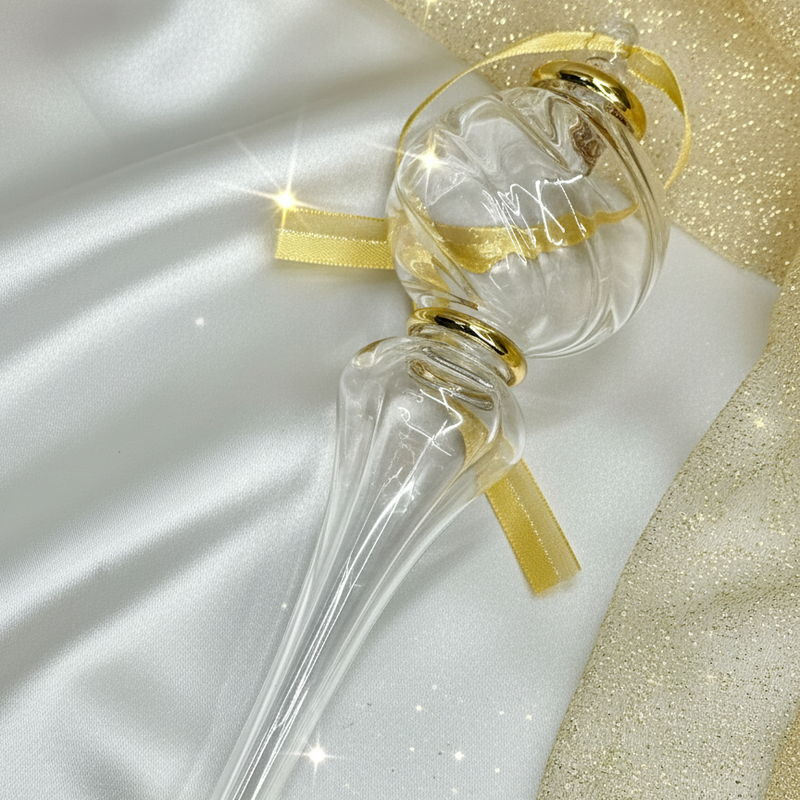 Decorative glass bottle with gold accents on a white and gold fabric background