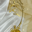 Decorative gold hourglass with intricate design on a white and gold fabric background