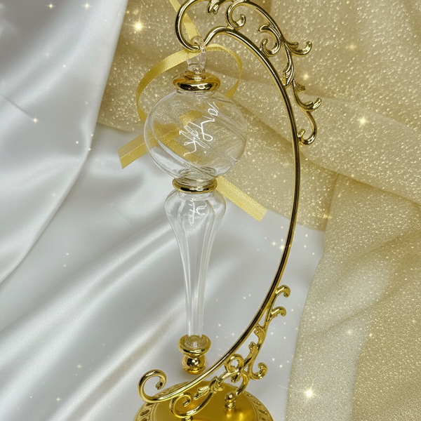 Decorative gold hourglass with intricate design on a white and gold fabric background