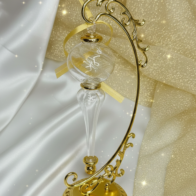 Decorative gold hourglass with intricate design on a white and gold fabric background