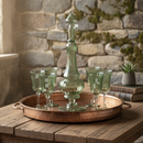 Decorative glass set on a copper tray with a stone wall background