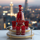 Red decorative bottle and cups on a marble tray with cityscape background