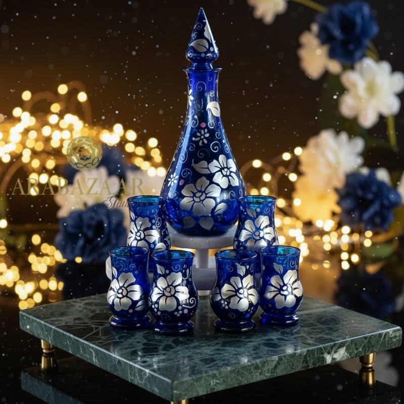 Set of blue glassware with white floral patterns on a dark background with blurred lights and flowers.