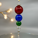 Decorative hanging ornament with red, blue, and green glass beads on a neutral background.