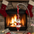 Glass Santa Claus ornament with a fireplace and stockings in the background