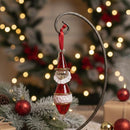 Decorative Christmas ornament with a red and white design on a blurred festive background.