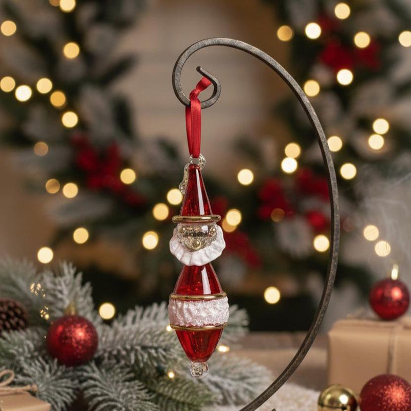 Decorative Christmas ornament with a red and white design on a blurred festive background.