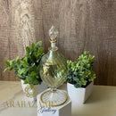 Decorative glass bottle with plants on a wooden background, featuring the brand 'ARABAZA'.