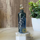 Decorative blue bottle with intricate design on a wooden surface, featuring the brand 'Arabazaar Gallery'.