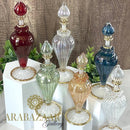Collection of colorful glass bottles on white stands with 'Arabesque Gallery' branding.